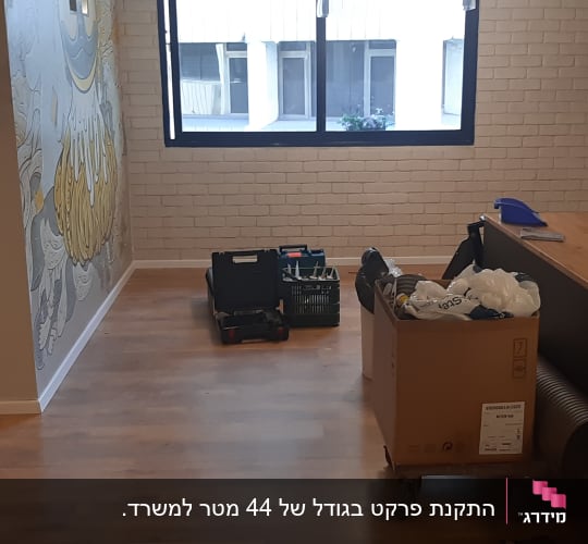 רצפת פרקט עם קופסאות וכלים על הרצפה